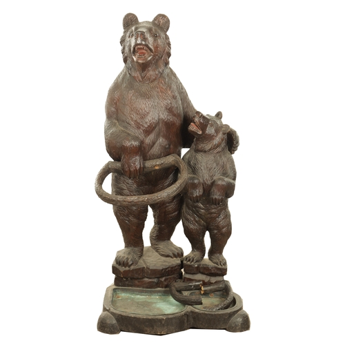 910 - A LATE 19TH CENTURY CARVED BLACK FOREST BEAR AND CUB STICK STAND modelled as a standing bear with he... 