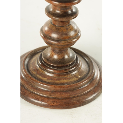 913 - A PAIR OF 19TH CENTURY TURNED WALNUT TREENWARE CANDLESTICKS having knopped turned stems and dished b... 