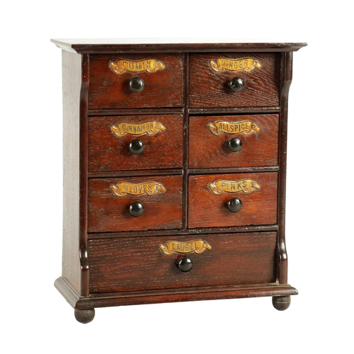 920 - A 19TH CENTURY OAK SPICE CABINET the open front fitted with an arrangement of 7 labelled small drawe... 