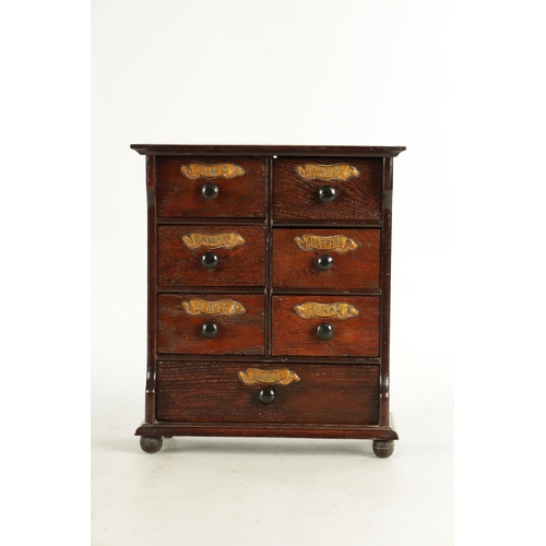 920 - A 19TH CENTURY OAK SPICE CABINET the open front fitted with an arrangement of 7 labelled small drawe... 