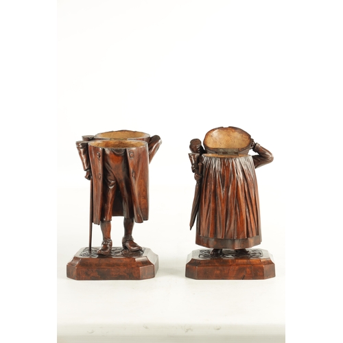 930 - A FINE PAIR OF 19TH CENTURY CARVED WALNUT BLACK FOREST TABACO JARS depicting a lady and gentleman, h... 