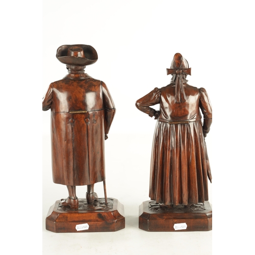 930 - A FINE PAIR OF 19TH CENTURY CARVED WALNUT BLACK FOREST TABACO JARS depicting a lady and gentleman, h... 