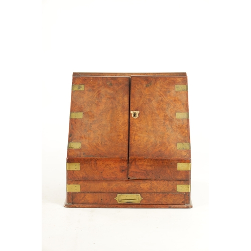 933 - A 19TH CENTURY BRASS BOUND FIGURED WALNUT STATIONARY CABINET with hinged sloping doors revealing a f... 