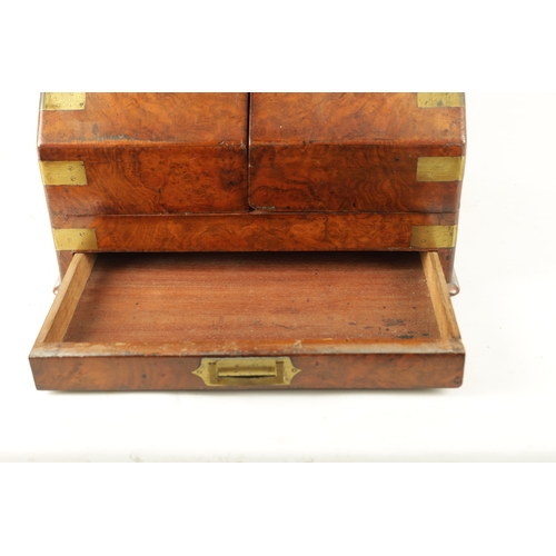 933 - A 19TH CENTURY BRASS BOUND FIGURED WALNUT STATIONARY CABINET with hinged sloping doors revealing a f... 