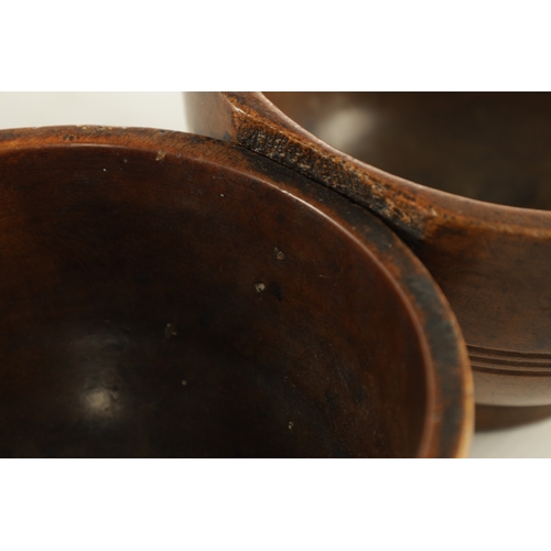 938 - A JOINED PAIR OF 19TH CENTURY WELSH TREEN CAWL BOWLS, with carved banding around the bodies and rais... 