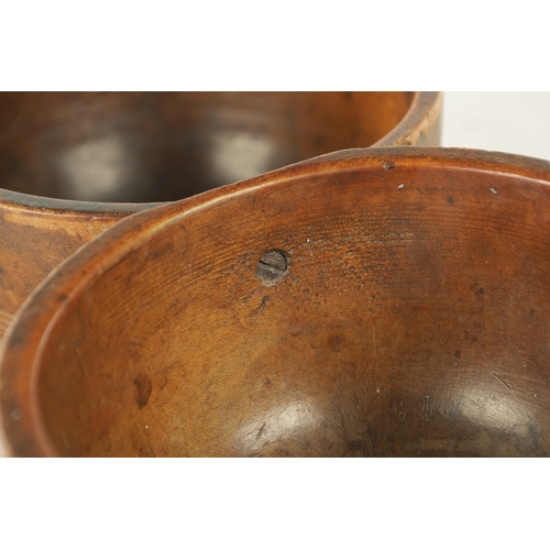 938 - A JOINED PAIR OF 19TH CENTURY WELSH TREEN CAWL BOWLS, with carved banding around the bodies and rais... 