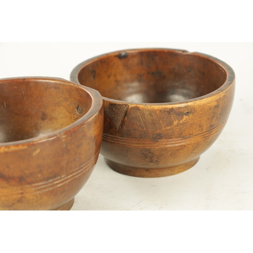 938 - A JOINED PAIR OF 19TH CENTURY WELSH TREEN CAWL BOWLS, with carved banding around the bodies and rais... 