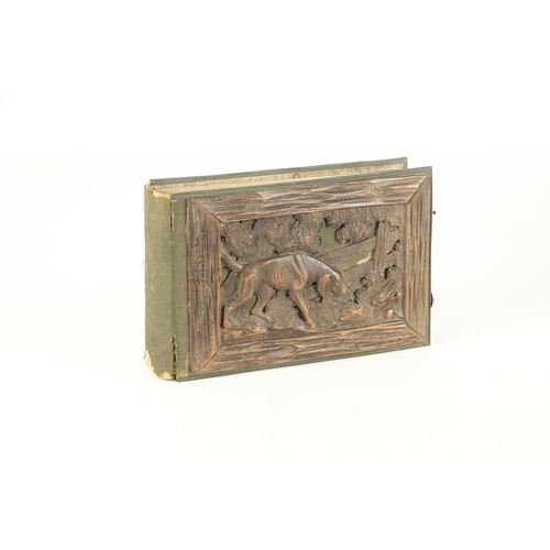 950 - A 19TH CENTURY BLACK FOREST PHOTO ALBUM with carved cover having a hound in a country setting (25cm ... 