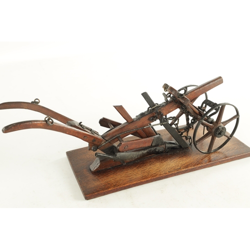 955 - A GOOD 19TH CENTURY OAK AND STEEL MODEL OF A HAND HELD PLOUGH finely made with spoked wheels and adj... 