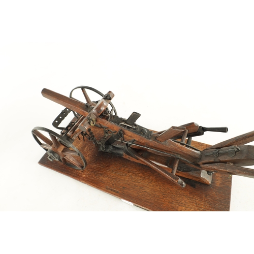 955 - A GOOD 19TH CENTURY OAK AND STEEL MODEL OF A HAND HELD PLOUGH finely made with spoked wheels and adj... 