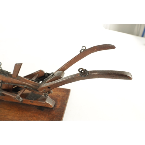 955 - A GOOD 19TH CENTURY OAK AND STEEL MODEL OF A HAND HELD PLOUGH finely made with spoked wheels and adj... 