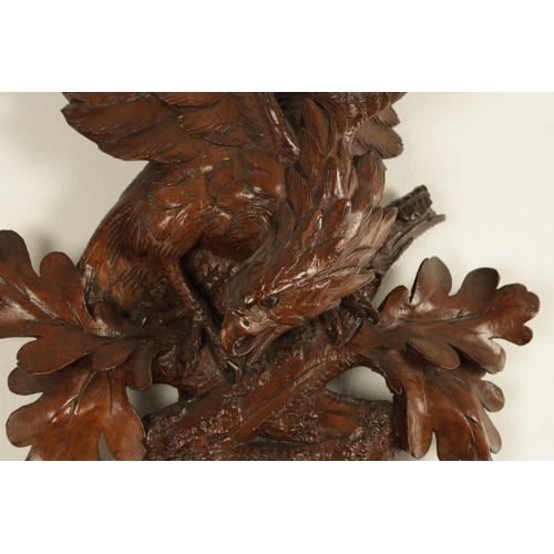 1028 - A LATE 19TH CENTURY BLACK FOREST CARVED BAROMETER, the case surmounted by an eagle above a carved oa... 