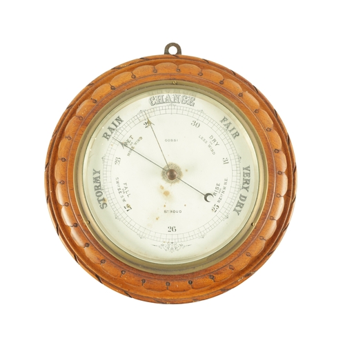 1204 - A LATE 19TH CENTURY ANEROID BAROMETER having a carved walnut surround with cast brass bezel enclosin... 