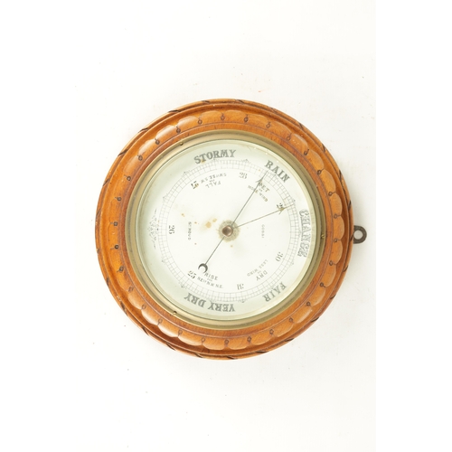 1204 - A LATE 19TH CENTURY ANEROID BAROMETER having a carved walnut surround with cast brass bezel enclosin... 