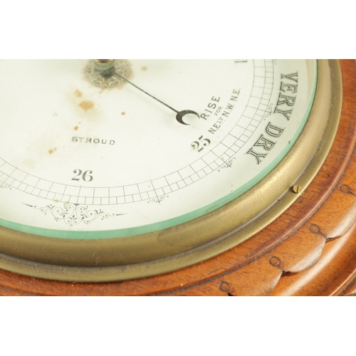 1204 - A LATE 19TH CENTURY ANEROID BAROMETER having a carved walnut surround with cast brass bezel enclosin... 