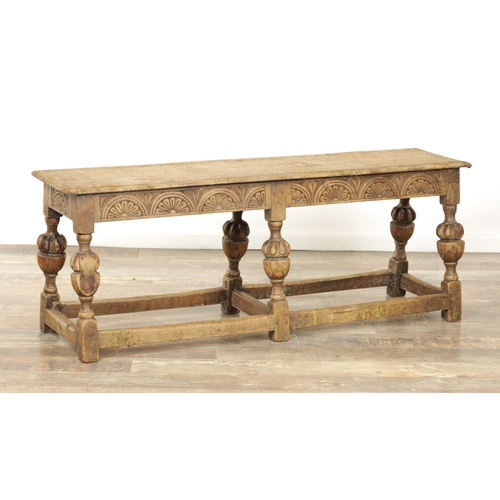 1227 - A 17TH CENTURY STYLE OAK LONG JOINT STOOL with an arcaded carved frieze above bulbous turned legs jo... 