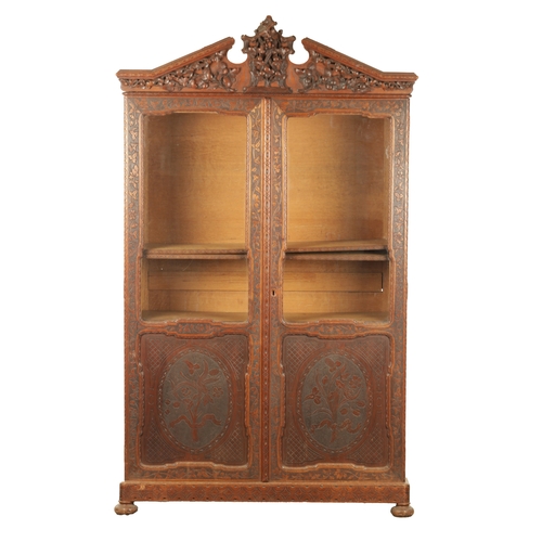 1232 - A 19TH CENTURY CARVED WALNUT BLACK FOREST DISPLAY CABINET OF SMALL SIZE with hinged glazed doors hav... 