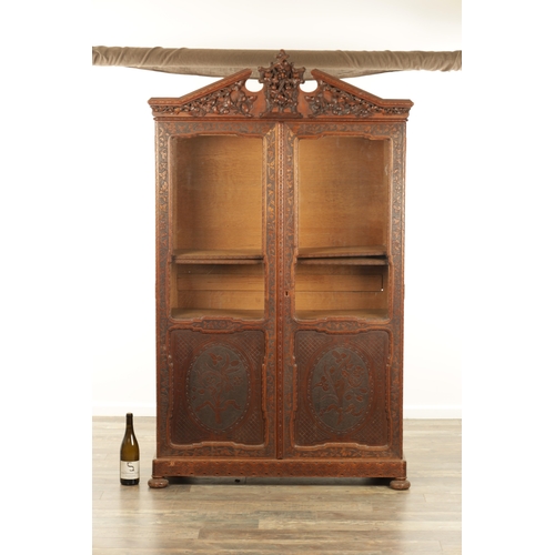 1232 - A 19TH CENTURY CARVED WALNUT BLACK FOREST DISPLAY CABINET OF SMALL SIZE with hinged glazed doors hav... 