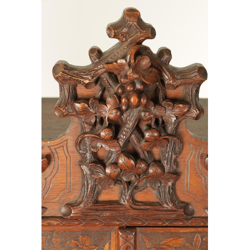 1232 - A 19TH CENTURY CARVED WALNUT BLACK FOREST DISPLAY CABINET OF SMALL SIZE with hinged glazed doors hav... 