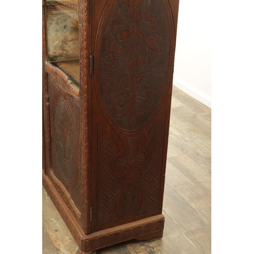 1232 - A 19TH CENTURY CARVED WALNUT BLACK FOREST DISPLAY CABINET OF SMALL SIZE with hinged glazed doors hav... 