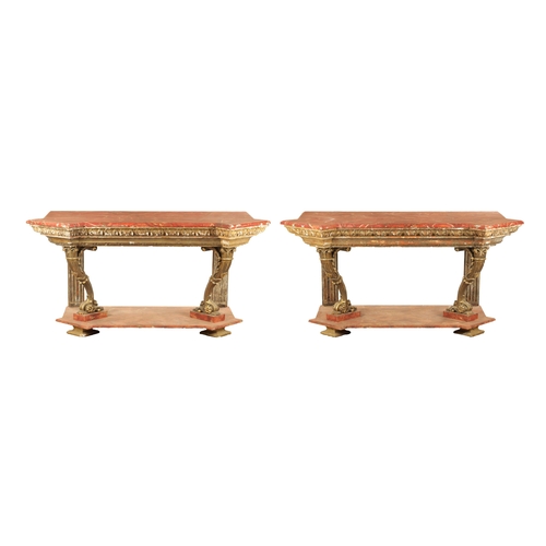 1256 - A STYLISH PAIR OF CARVED GILTWOOD AND SCUMBLED MARBLE CONSOLE TABLES having outset corners raised on... 