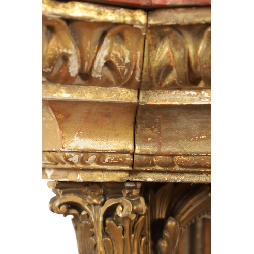 1256 - A STYLISH PAIR OF CARVED GILTWOOD AND SCUMBLED MARBLE CONSOLE TABLES having outset corners raised on... 