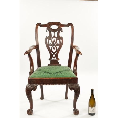 1263 - AN 18TH CENTURY WALNUT OPEN ARM CHAIR the carved eared top rail above a tassel tied shaped and fret ... 