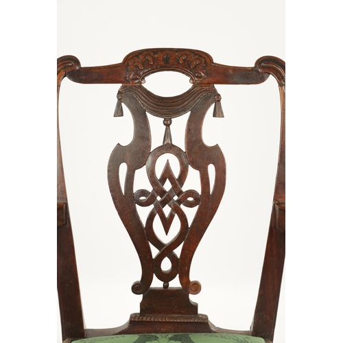 1263 - AN 18TH CENTURY WALNUT OPEN ARM CHAIR the carved eared top rail above a tassel tied shaped and fret ... 