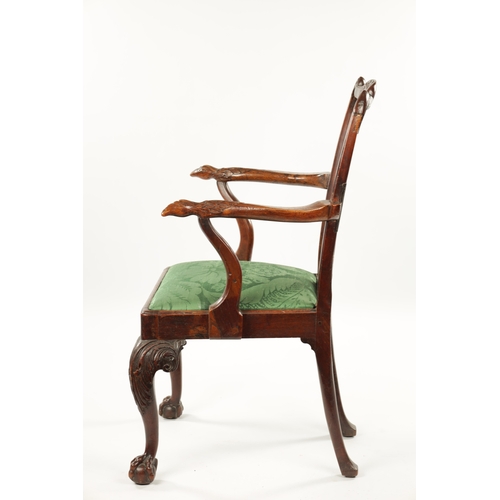 1263 - AN 18TH CENTURY WALNUT OPEN ARM CHAIR the carved eared top rail above a tassel tied shaped and fret ... 