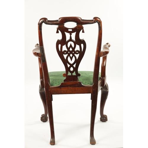 1263 - AN 18TH CENTURY WALNUT OPEN ARM CHAIR the carved eared top rail above a tassel tied shaped and fret ... 