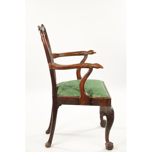 1263 - AN 18TH CENTURY WALNUT OPEN ARM CHAIR the carved eared top rail above a tassel tied shaped and fret ... 