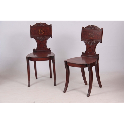 1280 - A PAIR OF REGENCY MAHOGANY HALL CHAIRS with scrolled carved backs and painted coats of arms to the p... 