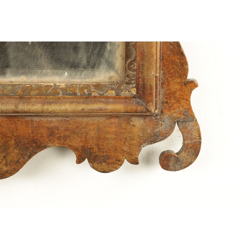 1288 - A GEORGE III WALNUT HANGING MIRROR with shaped surround enclosing a parcel gilt edge surround and mi... 