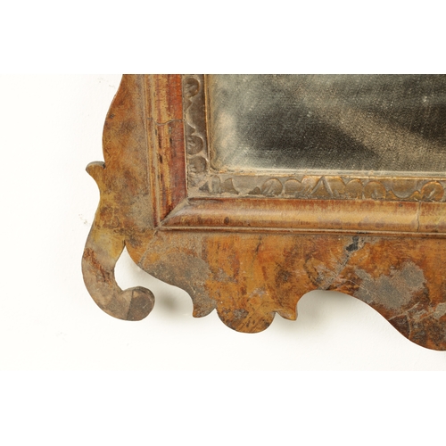 1288 - A GEORGE III WALNUT HANGING MIRROR with shaped surround enclosing a parcel gilt edge surround and mi... 