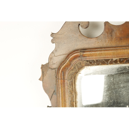 1288 - A GEORGE III WALNUT HANGING MIRROR with shaped surround enclosing a parcel gilt edge surround and mi... 