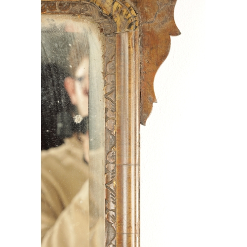 1288 - A GEORGE III WALNUT HANGING MIRROR with shaped surround enclosing a parcel gilt edge surround and mi... 