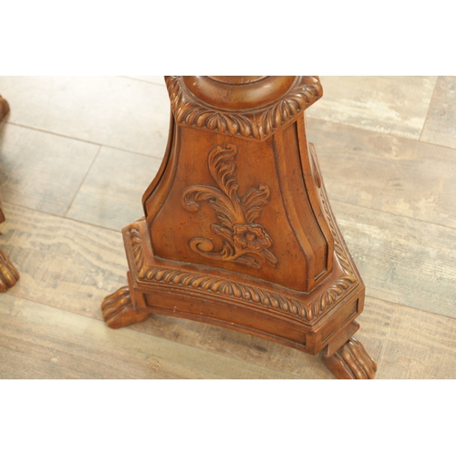 1304 - A PAIR OF 20TH CENTURY WALNUT TORCHERES with bulbous turned stem and raised on triform bases with cl... 