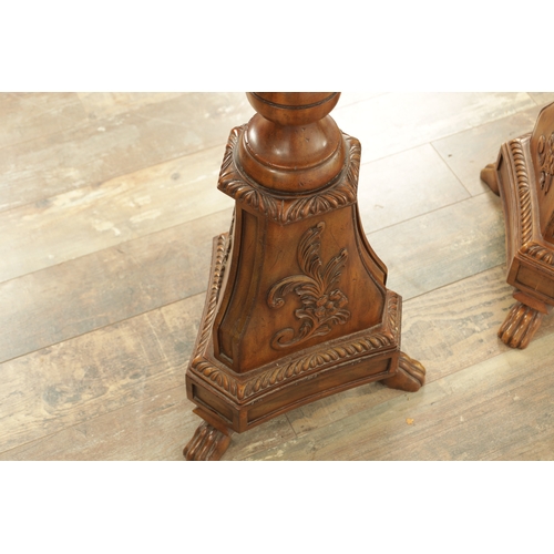 1304 - A PAIR OF 20TH CENTURY WALNUT TORCHERES with bulbous turned stem and raised on triform bases with cl... 