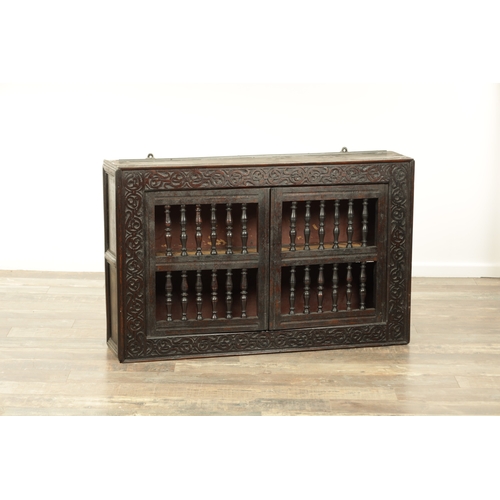 1314 - A 17TH-CENTURY OAK HANGING MURAL / DOLE CUPBOARD with turned spindle hinged doors surrounded by carv... 