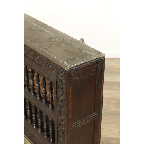 1314 - A 17TH-CENTURY OAK HANGING MURAL / DOLE CUPBOARD with turned spindle hinged doors surrounded by carv... 