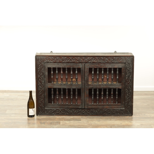 1314 - A 17TH-CENTURY OAK HANGING MURAL / DOLE CUPBOARD with turned spindle hinged doors surrounded by carv... 