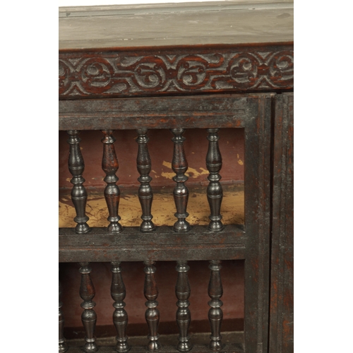 1314 - A 17TH-CENTURY OAK HANGING MURAL / DOLE CUPBOARD with turned spindle hinged doors surrounded by carv... 