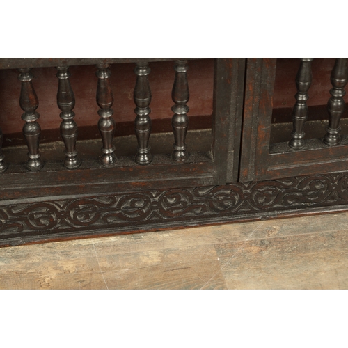 1314 - A 17TH-CENTURY OAK HANGING MURAL / DOLE CUPBOARD with turned spindle hinged doors surrounded by carv... 