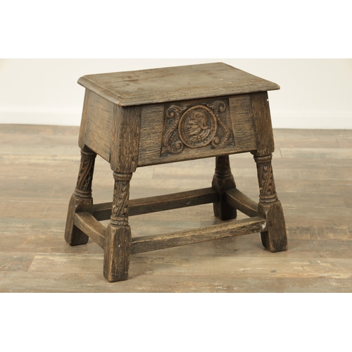 1323 - A 17TH CENTURY STYLE JOINED OAK BOX STOOL with a hinged top above a masked carved frieze raised on c... 