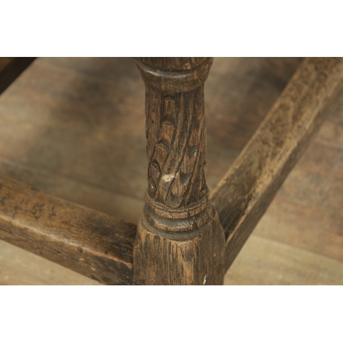 1323 - A 17TH CENTURY STYLE JOINED OAK BOX STOOL with a hinged top above a masked carved frieze raised on c... 