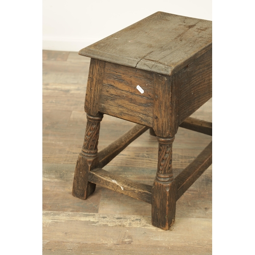 1323 - A 17TH CENTURY STYLE JOINED OAK BOX STOOL with a hinged top above a masked carved frieze raised on c... 