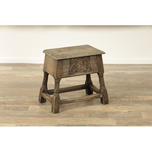 1323 - A 17TH CENTURY STYLE JOINED OAK BOX STOOL with a hinged top above a masked carved frieze raised on c... 