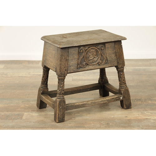 1323 - A 17TH CENTURY STYLE JOINED OAK BOX STOOL with a hinged top above a masked carved frieze raised on c... 