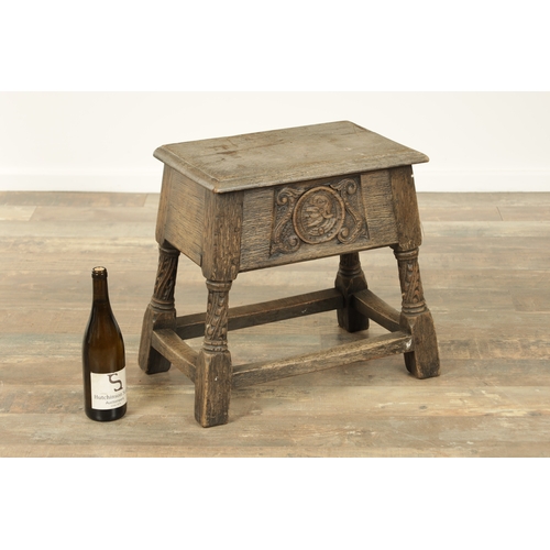 1323 - A 17TH CENTURY STYLE JOINED OAK BOX STOOL with a hinged top above a masked carved frieze raised on c... 