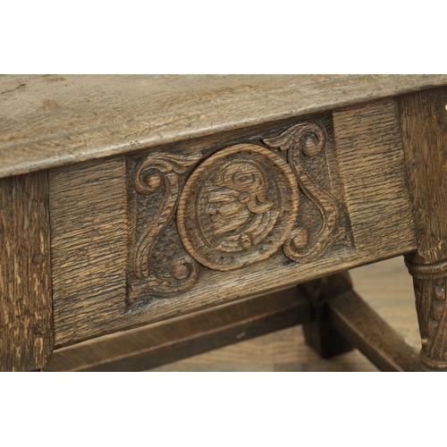 1323 - A 17TH CENTURY STYLE JOINED OAK BOX STOOL with a hinged top above a masked carved frieze raised on c... 